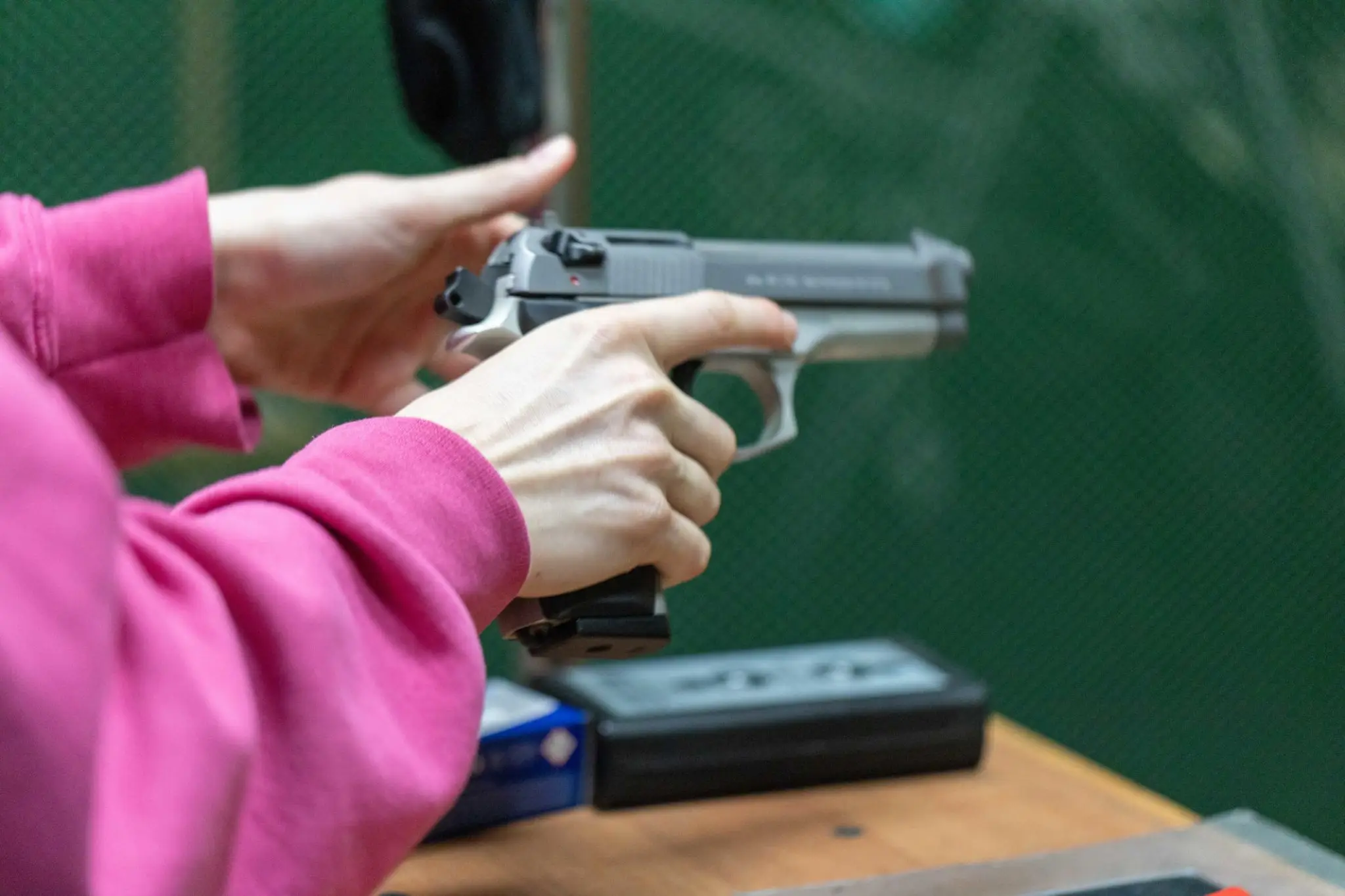 lady cocking back the slide of a pistol