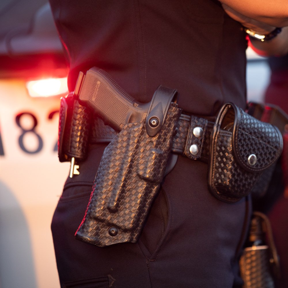 police officer with gun in holder on his police belt